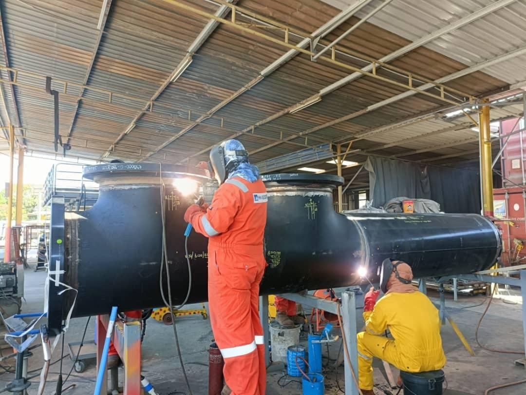 Welder fabricating a large pipe section